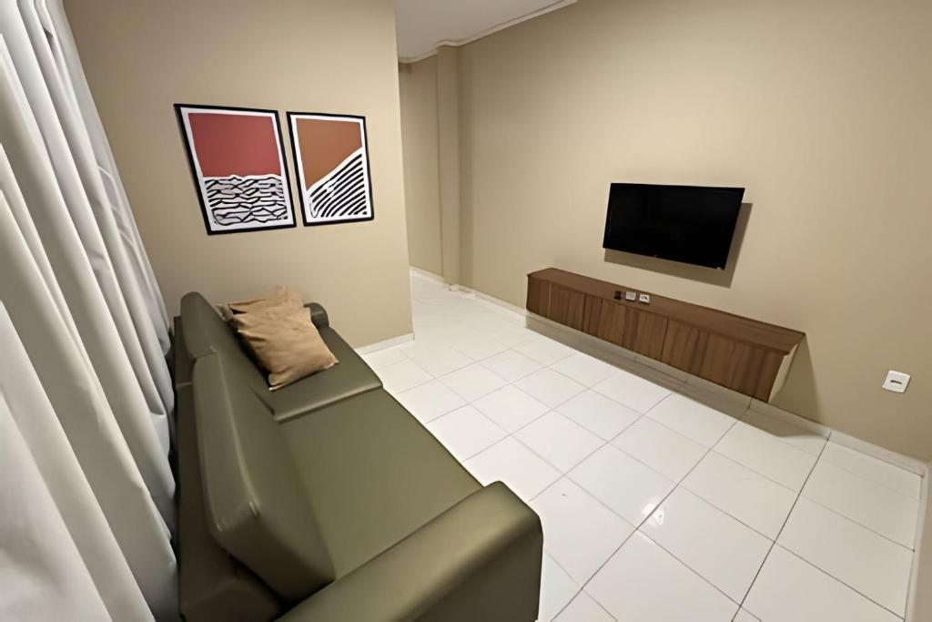 a living room with a couch and a television at Apê espaçoso e tranquilo pertinho do centro! in Barreiras