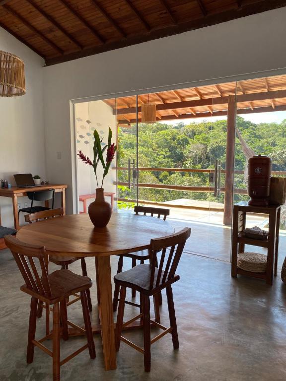 a wooden table with chairs and a vase on it at Divina Casa in Itacaré