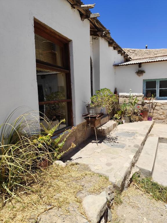 a white house with a table in front of it at Casa de Altura in Tilcara