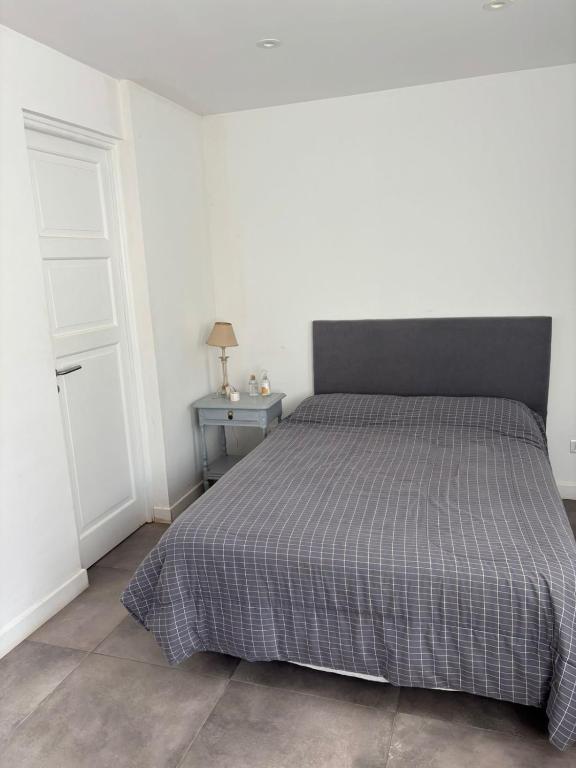 ein Schlafzimmer mit einem Bett und einem Tisch und einer Tür in der Unterkunft Departamento Roca in La Porteña