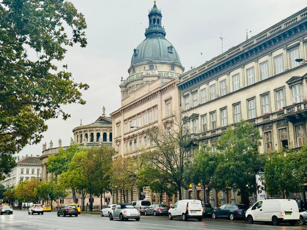 a large building with cars parked in front of it at Opera Central Stay in Budapest