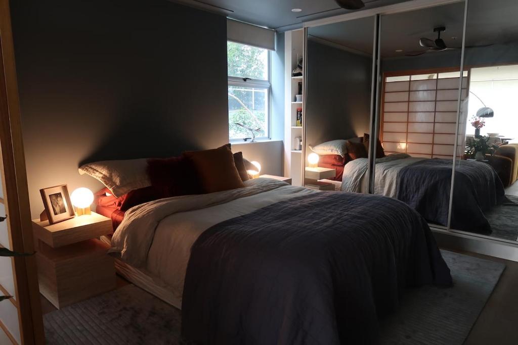 a bedroom with two beds and a large mirror at Mid-Century Luxe - Story Bridge & River Views in Brisbane