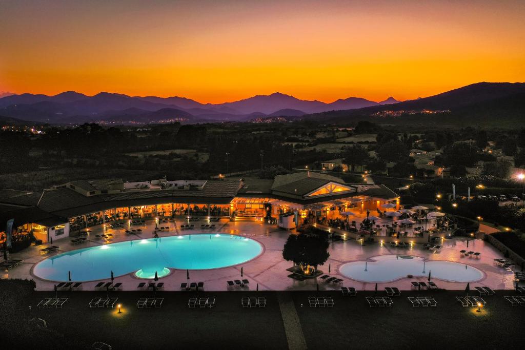 a view of a resort with two pools at sunset at Cala Fiorita in Agrustos