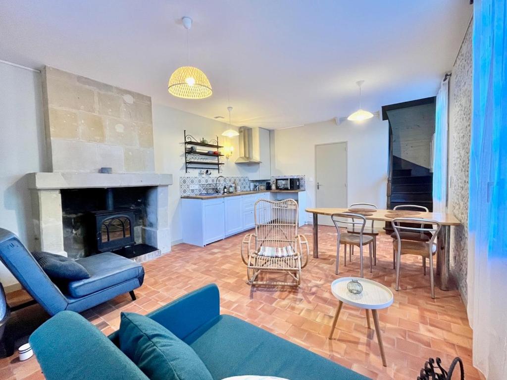 a living room with a blue couch and a table at Porterie du château Clim Wifi Terrasse Bord Loire in Gennes