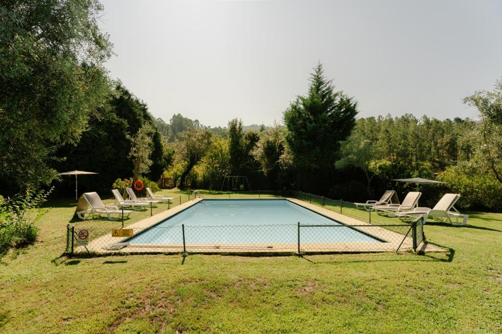 a swimming pool in a yard with lounge chairs at Quinta do Pomarinho - by RowdHouses in Arouca