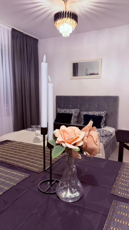 a room with a table with two candles and a bed at JAD Militari Residence in Roşu