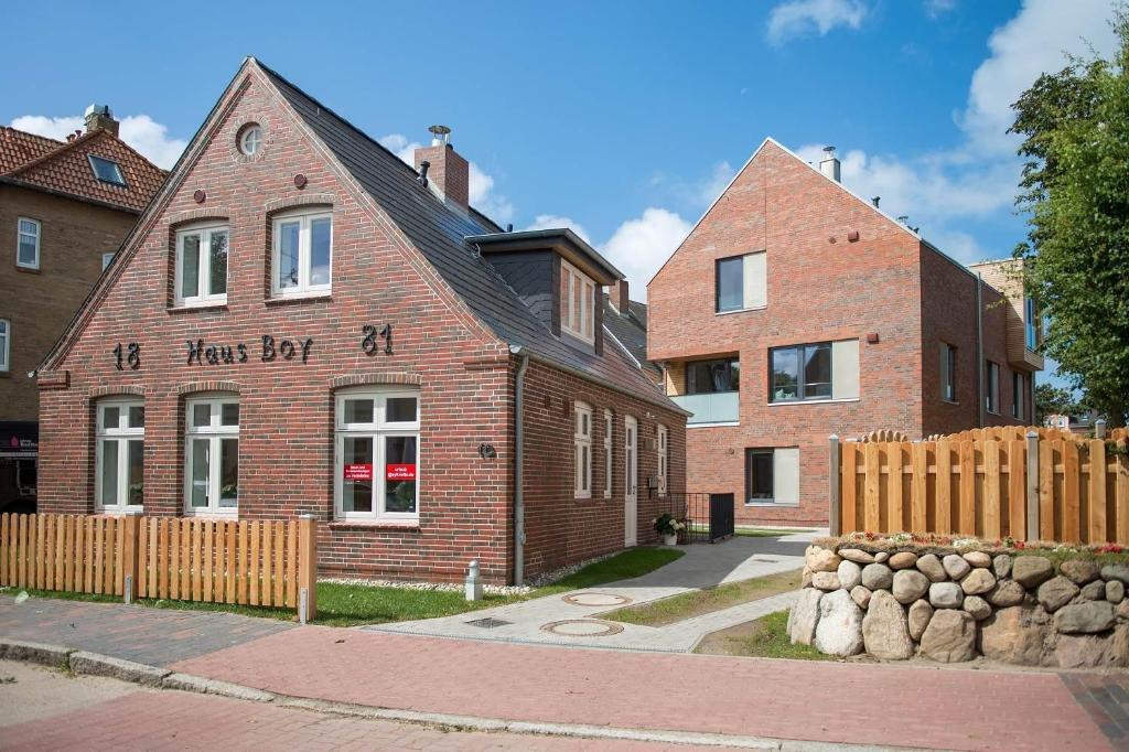 a brick building with a fence in front of it at Sylt Lofts in Westerland