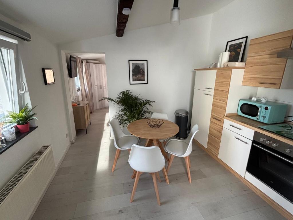 a kitchen with a table and chairs in a room at Wohnung nähe Phantasialand und Köln in Hürth