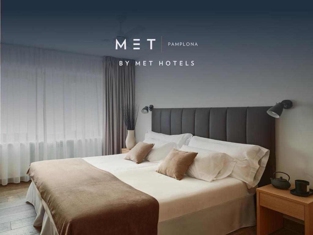 a bedroom with a bed with white sheets and pillows at MET Pamplona By MET HOTELS in Pamplona