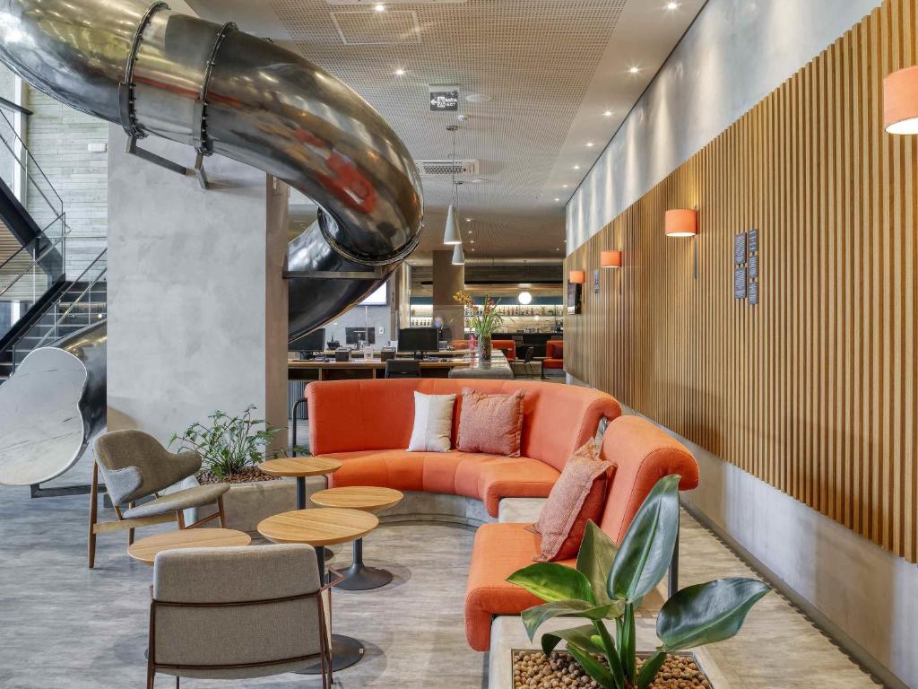 a lobby with a couch and chairs and a table at Novotel BH Savassi in Belo Horizonte