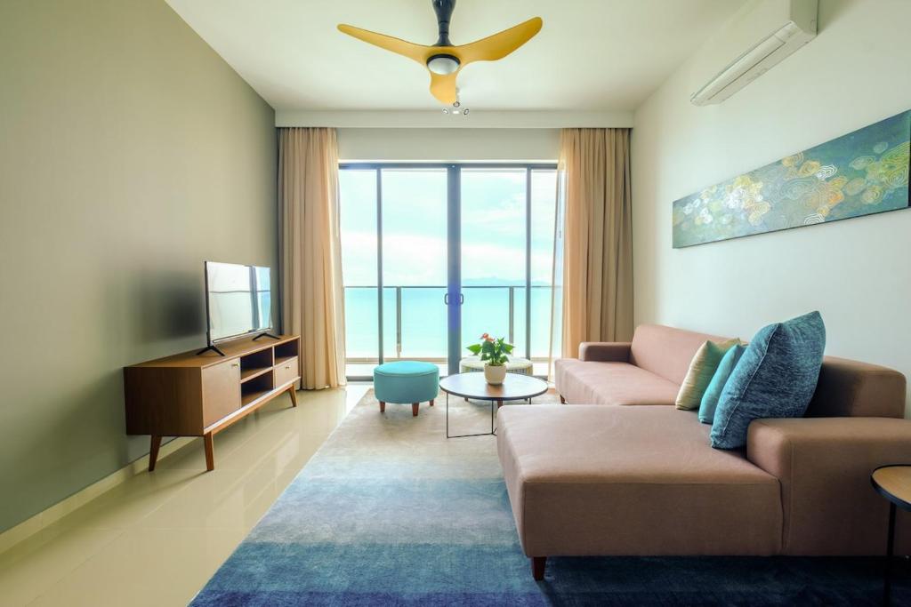 Tanjong TokongにあるPenang Beachfront Seaview Residencesのソファとテレビのあるリビングルーム