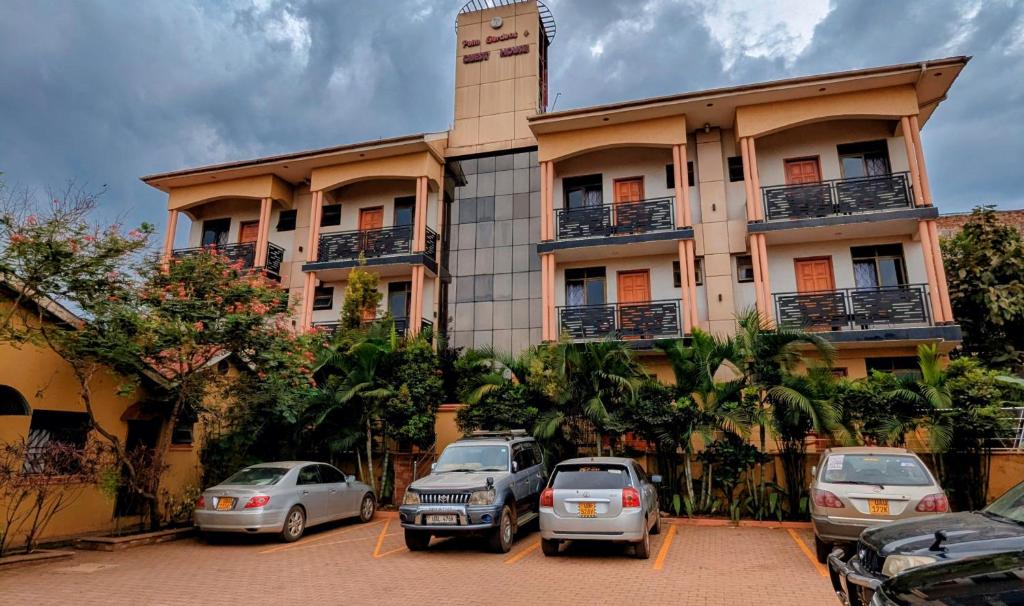 a building with cars parked in front of it at Palm Gardens Guesthouse in Kampala