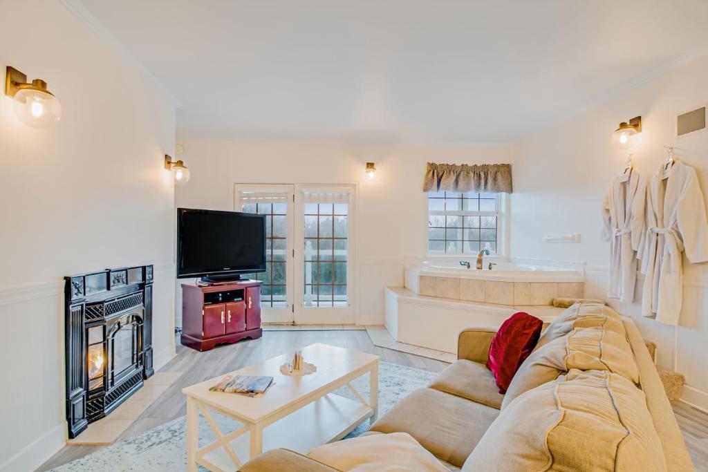 ein Wohnzimmer mit Sofa und Fernseher in der Unterkunft The Charleston at the Judith Ann Inn in Oyhut