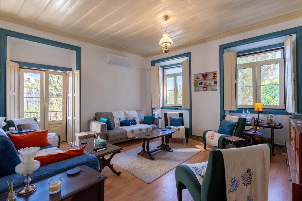 een woonkamer met banken, stoelen en ramen bij Casa Turquesa Pet-Friendly, Riverfront Home in Constância