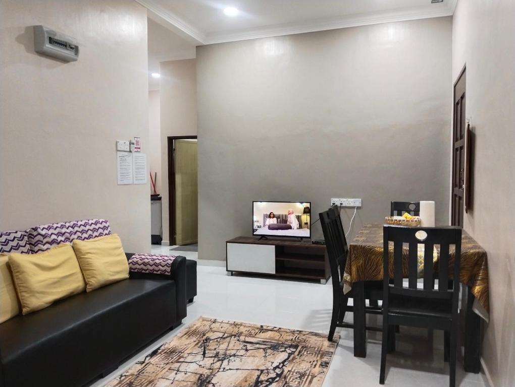 ein Wohnzimmer mit Couch und Tisch in der Unterkunft Homestay Salsabila Langkawi in Kampung Padang Masirat