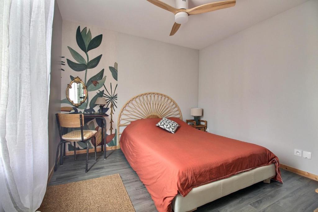 Schlafzimmer mit einem Bett, einem Ventilator und einem Stuhl in der Unterkunft Appartement T2 indépendant au coeur de la ville in Bourges