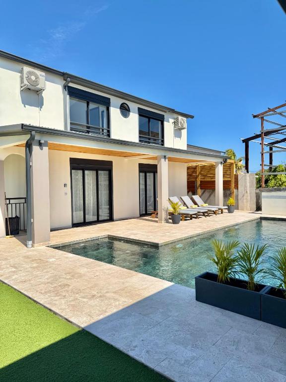 a house with a swimming pool in front of it at Villa Solaya - Sud Sauvage in Saint-Joseph