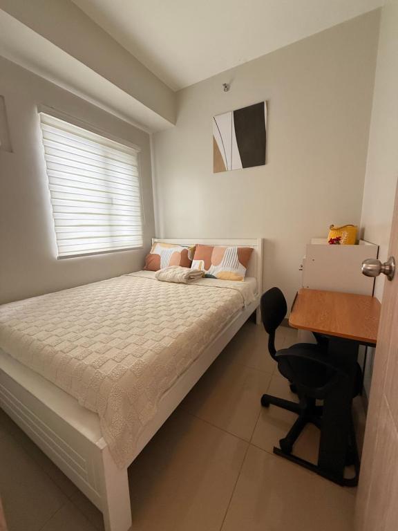 - une chambre avec un lit et un bureau dans l'établissement Urban Oasis 2BR Condo with Multiple Pools at SMDC Charm Residences, à Manille