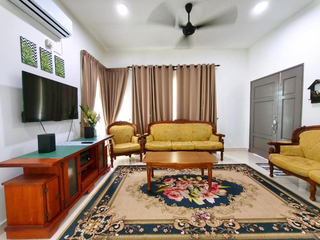 a living room with a couch and a tv at Ana Homestay Moslim only 4 airconds Wi-Fi in Alor Setar