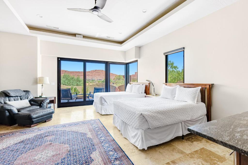 a bedroom with two beds and a chair at Red Rock Suite in Santa Clara