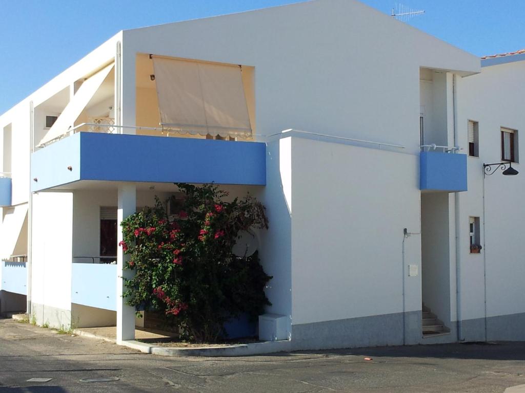 un edificio blanco con una planta a un lado en B&B Le tre Spiagge, en Calasetta