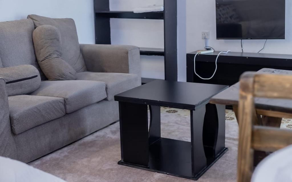 a living room with a couch and a table at Sinty's furnished homes in Narok