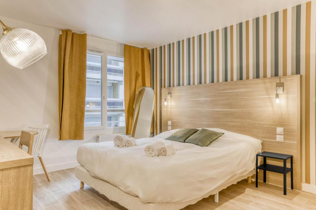 a bedroom with a large bed with two towels on it at Colivi Studio Cosy 50m Gare Annemasse in Annemasse