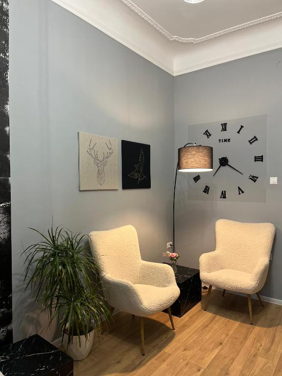 a room with two chairs and a clock on the wall at Danube Studio in Brăila