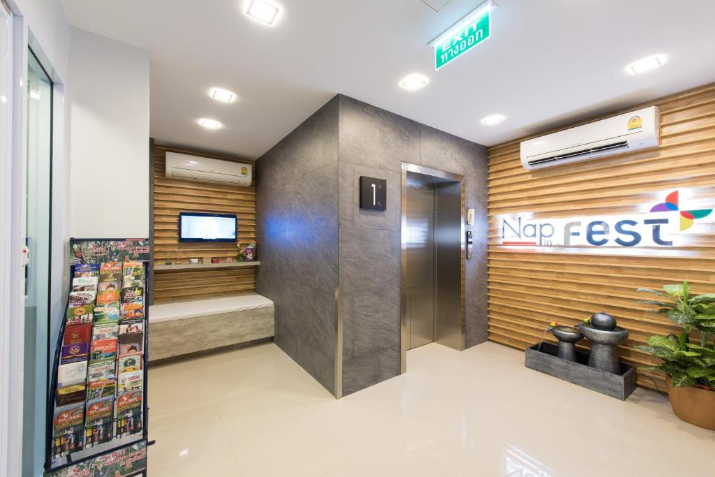 A bright hotel arrival area with elevators, a Nap Fest sign and a rack of local brochures.