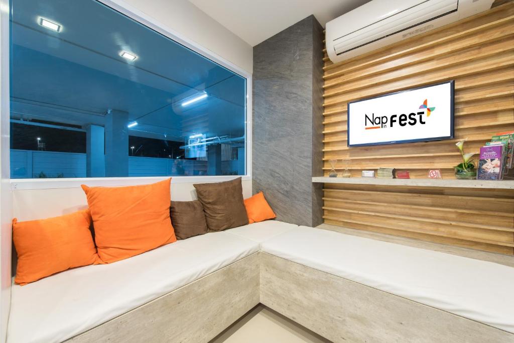 A built-in corner bench beside a large window in a branded hotel sitting area.