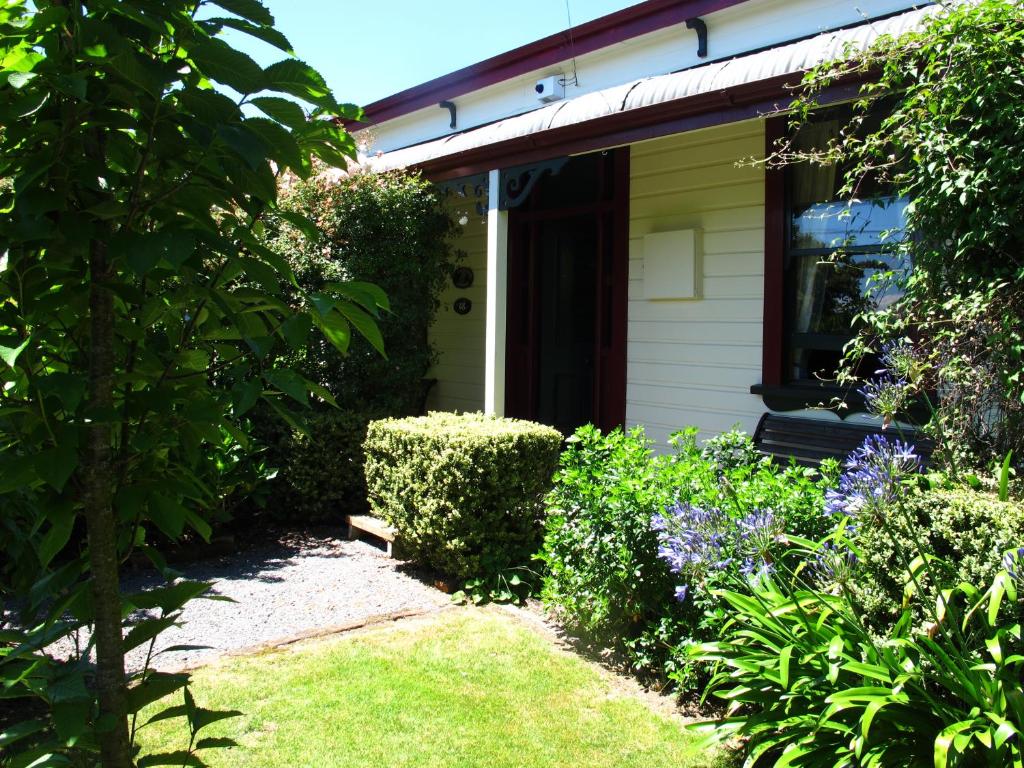 a house with a garden and flowers in front of it at Villa in the Vines in Martinborough 
