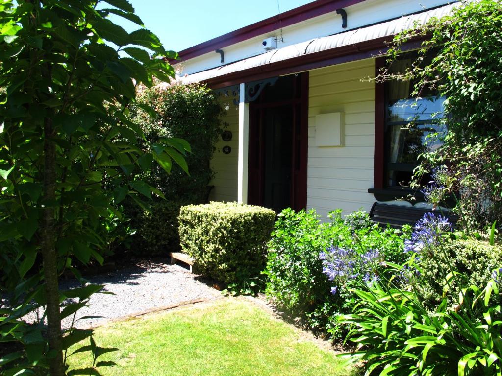 una casa con jardín y flores delante de ella en Villa in the Vines, en Martinborough