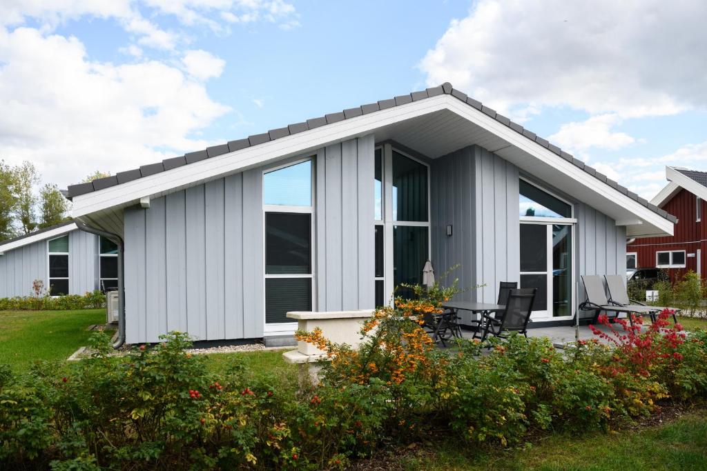 una casa bianca con finestre e patio di Seeschwalbe 330 a Mirow