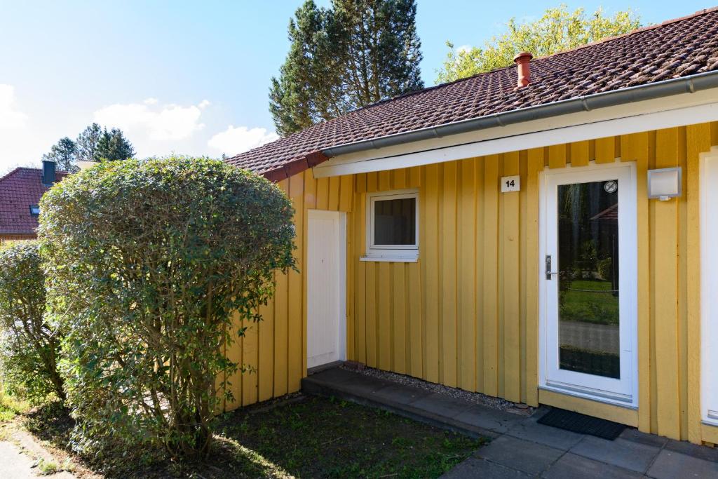 a yellow house with a tree in front of it at Möwe 14 in Mirow