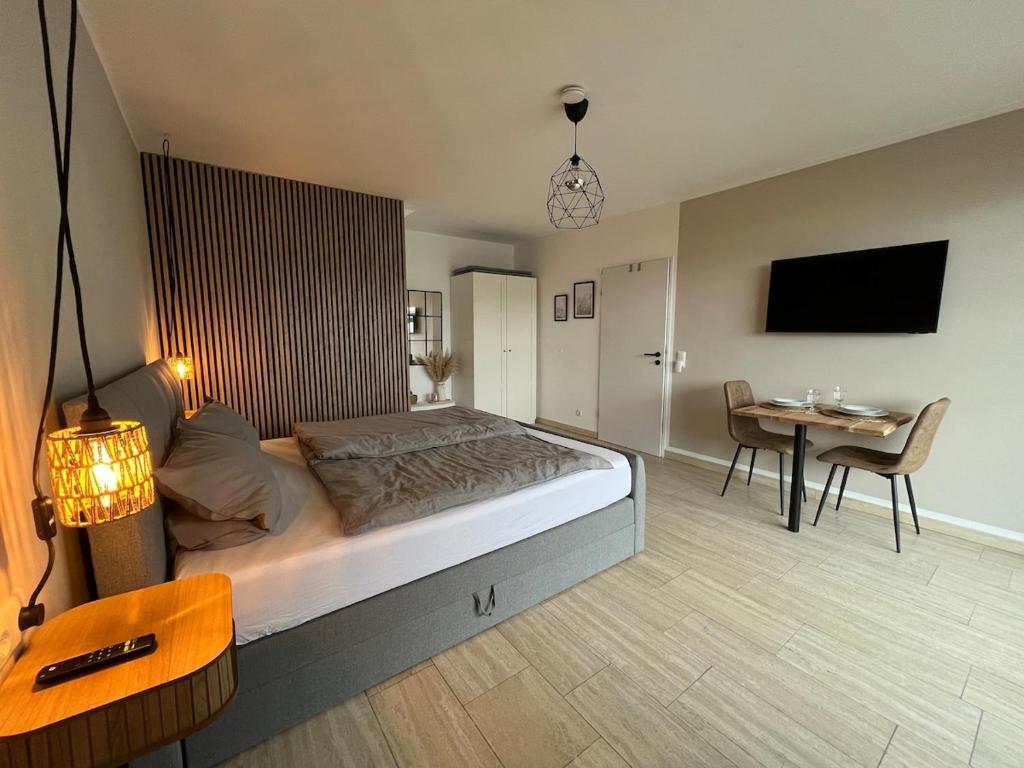 a bedroom with a bed and a table and a tv at Cozy apartment in Hagen