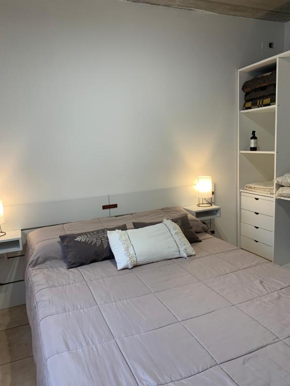 a bedroom with a large bed with a cross on the wall at Casa Monte hermoso a media cuadra Del Mar in Monte Hermoso