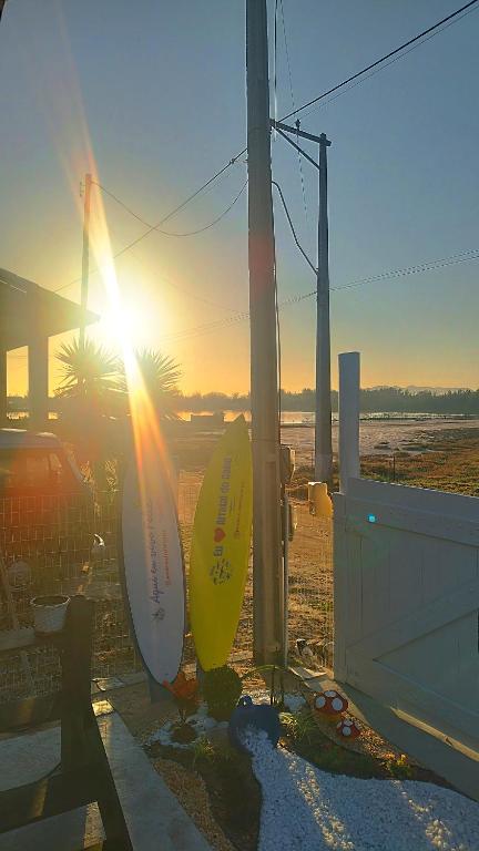 two surfboards leaning against a building with the sunset in the background at EcoChalé de Arraial in Arraial do Cabo