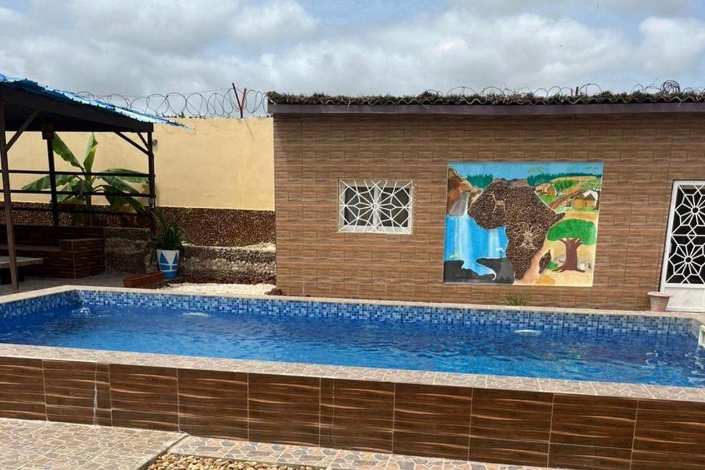 a large swimming pool next to a building with a painting at Seaside Villa Sleeps 2 with Ocean Views in Siendou