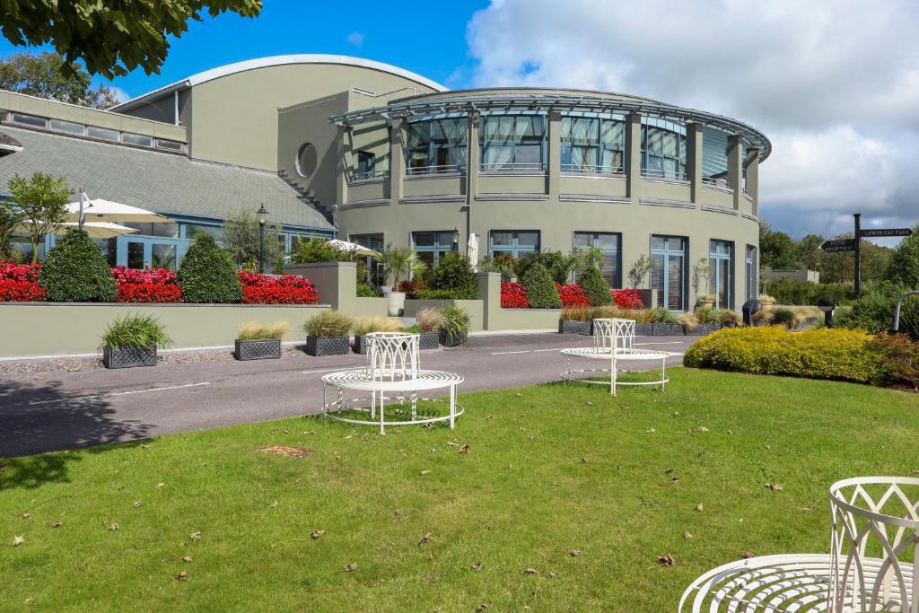 un edificio con mesas blancas delante de él en Ballyroe Lodge, en Tralee