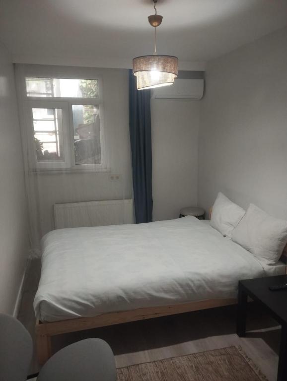 een slaapkamer met een wit bed met een raam bij Şişli Suites - Room47 in Istanbul