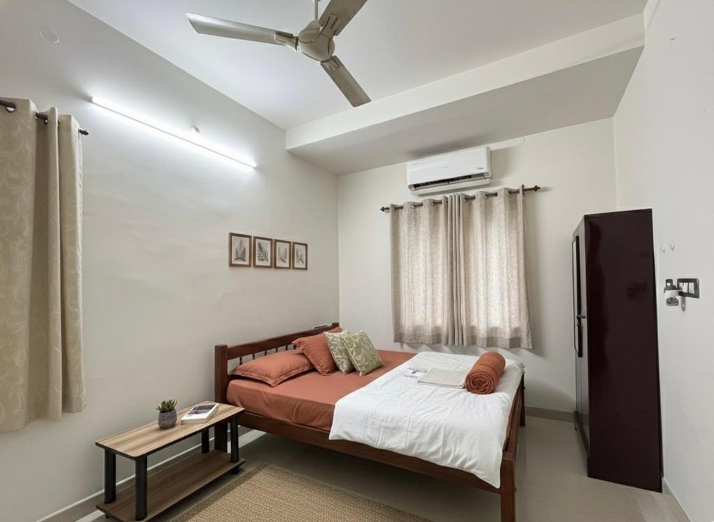 a bedroom with a bed and a table at Dream Nest Beach House in Alleppey