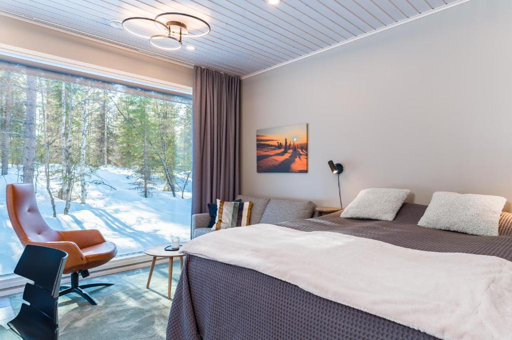 ein Schlafzimmer mit einem Bett und einem großen Fenster in der Unterkunft Halla Chalet, Northern Lights, ski & lake, free wifi, Vuosseli Resort Ruka in Kuusamo
