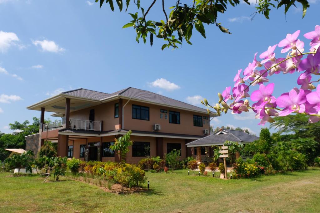 a house with pink flowers in front of it at K Garden Homestay Chiang Rai 
