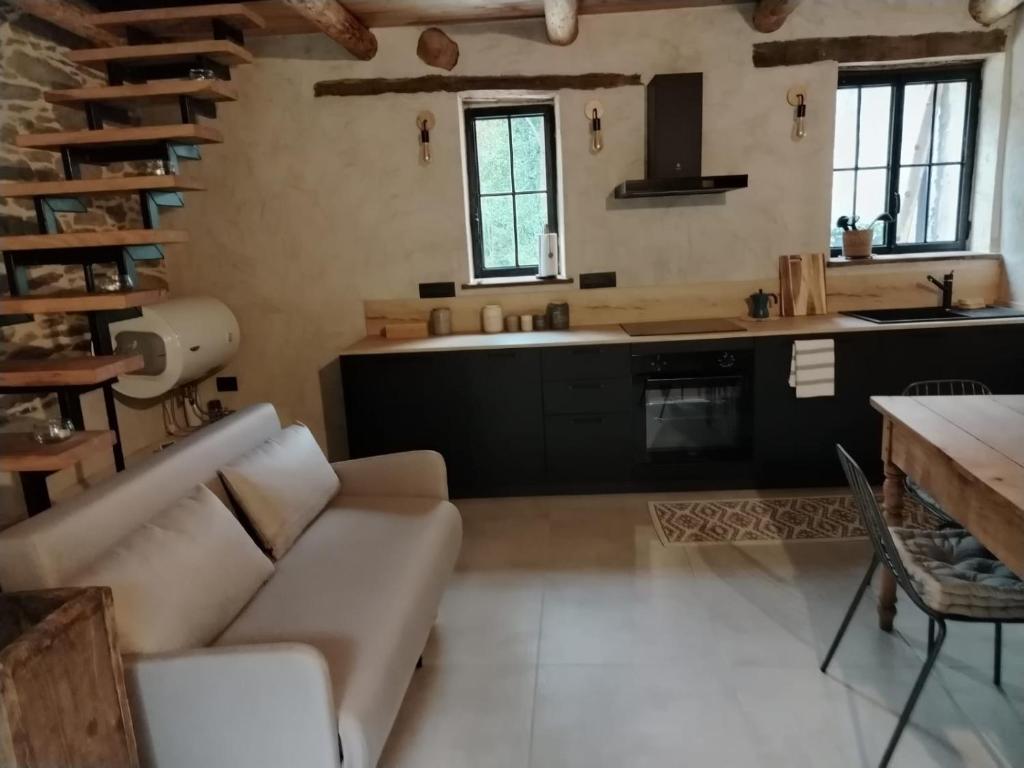 a living room with a couch and a kitchen at la stalla di mario in Perondo