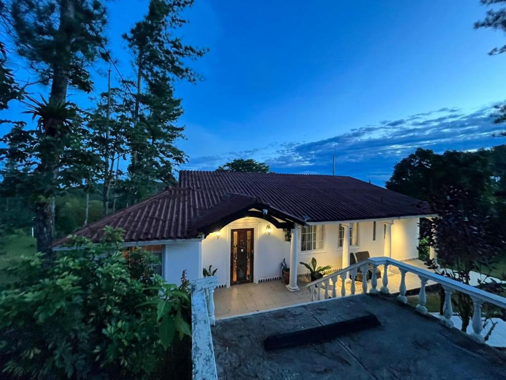 a small white house with a porch at night at MountainzenEscape in Los Altos de Cerro Azul