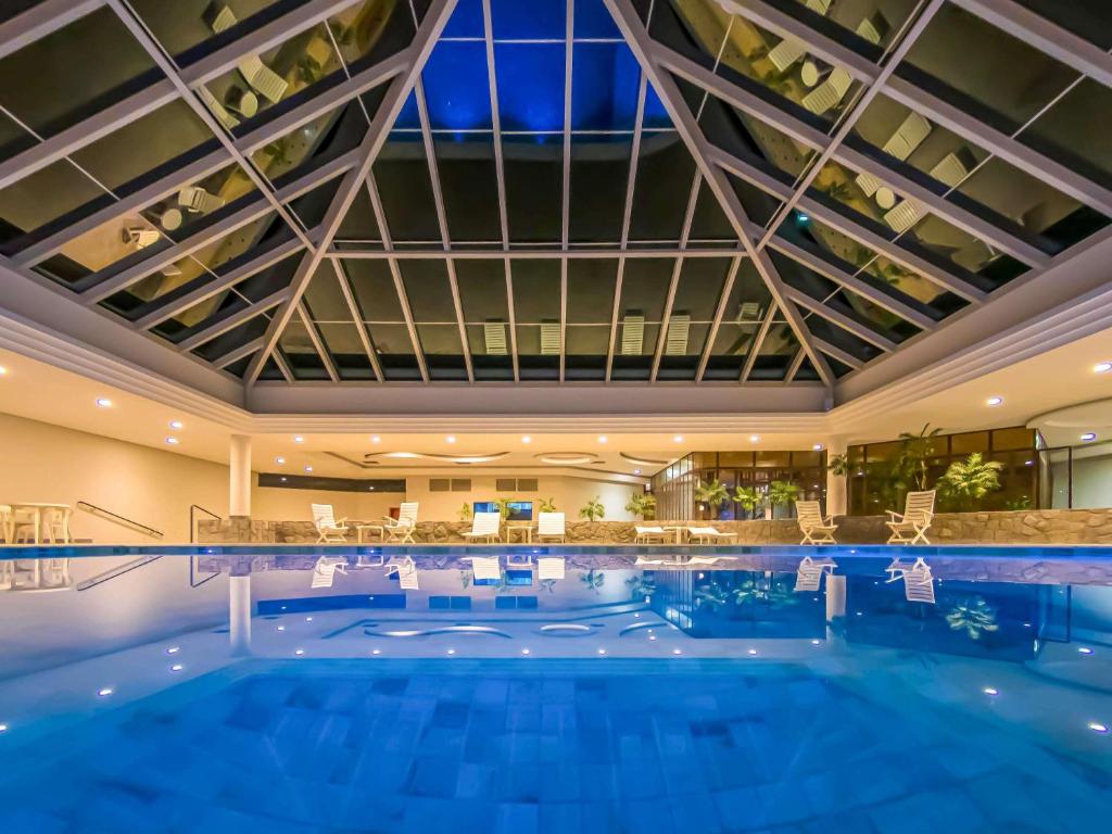 a large swimming pool in a hotel with a large ceiling at ibis Styles Sorocaba Santa Rosalia in Sorocaba