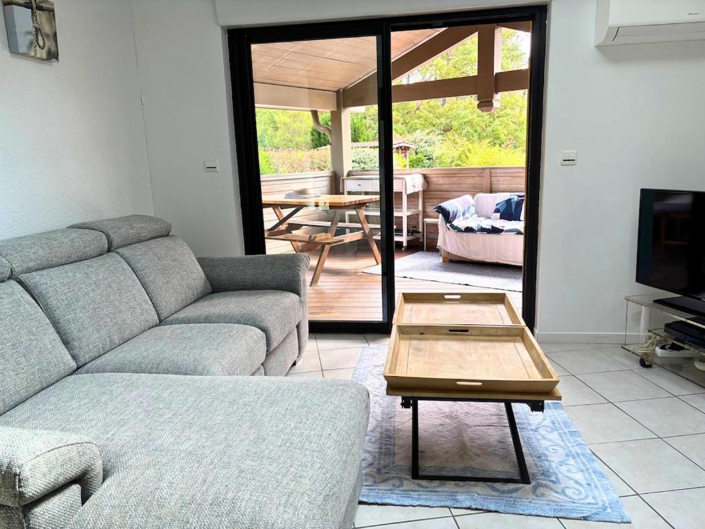 Una sala de estar con un sofá y una mesa de café. en Kôté Sea Apartment, en Seignosse
