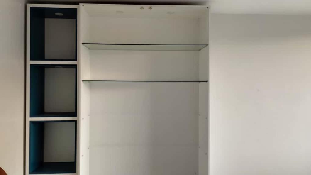 a white cabinet with glass shelves in a room at Hospedaje Aquaman in Hacienda El Recreo
