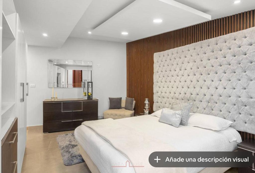 a bedroom with a large bed and a mirror at Vita House in Quito