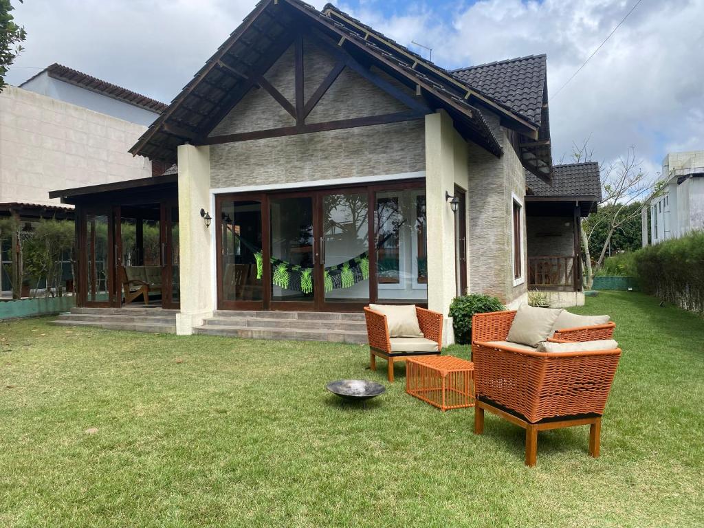 a house with two chairs and a fire pit in the yard at Águas da Serra Condomínio in Bananeiras